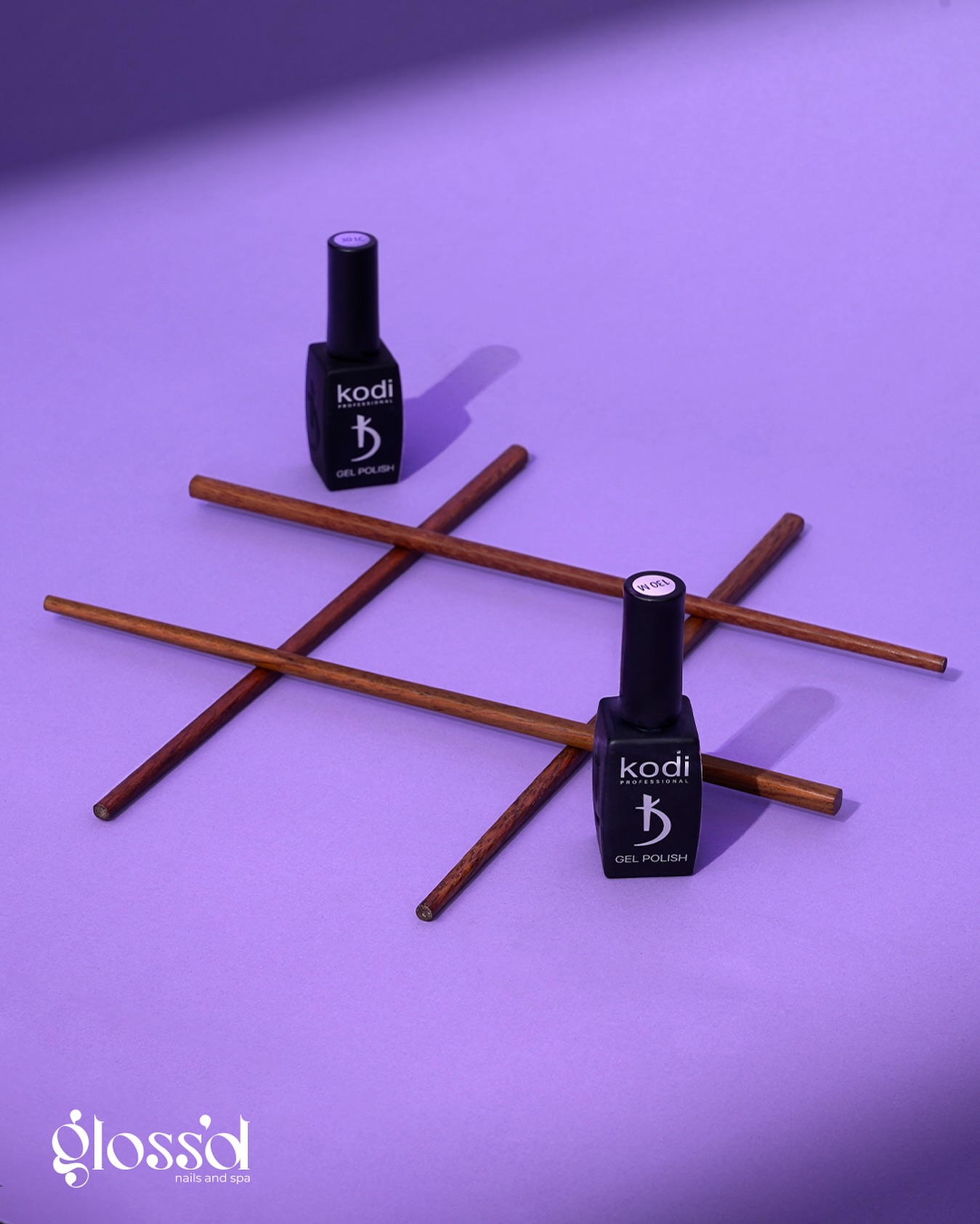 Nail polish bottles and manicure tools arranged on a purple background for a nail salon advertising campaign